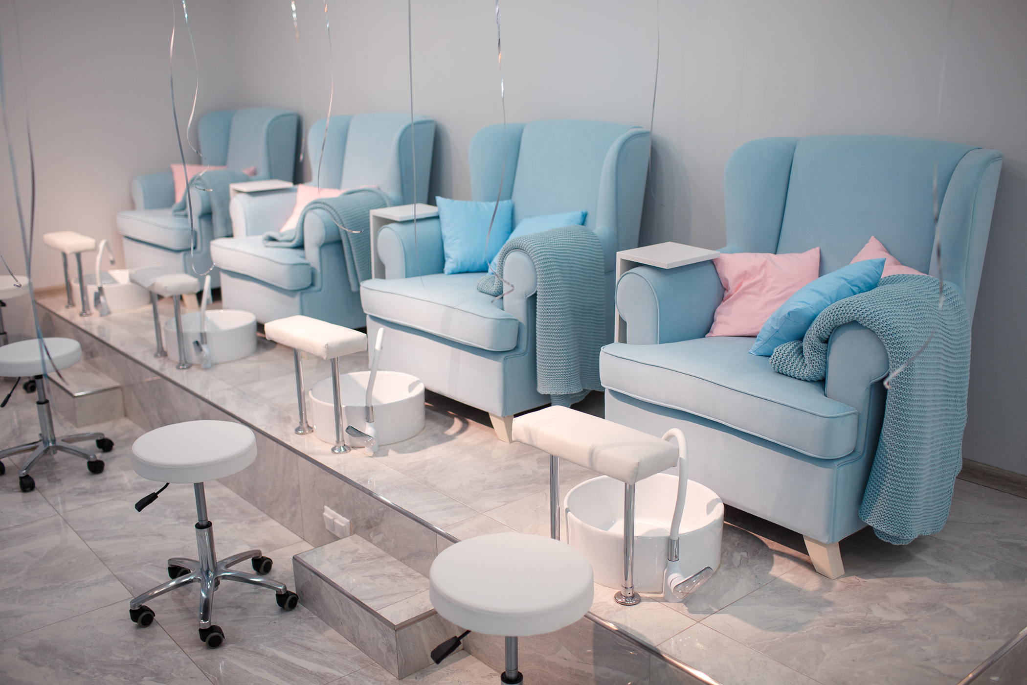 beauty salon with blue upholstered chairs for pedicure