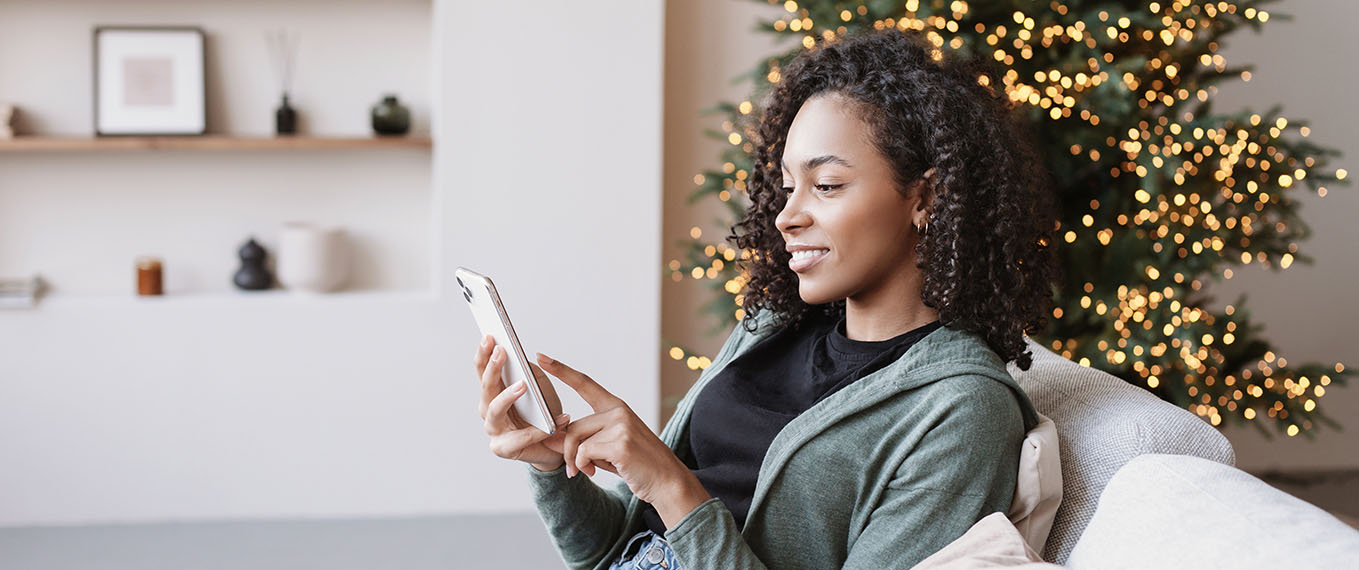 Woman using mobile home with Christmas tree